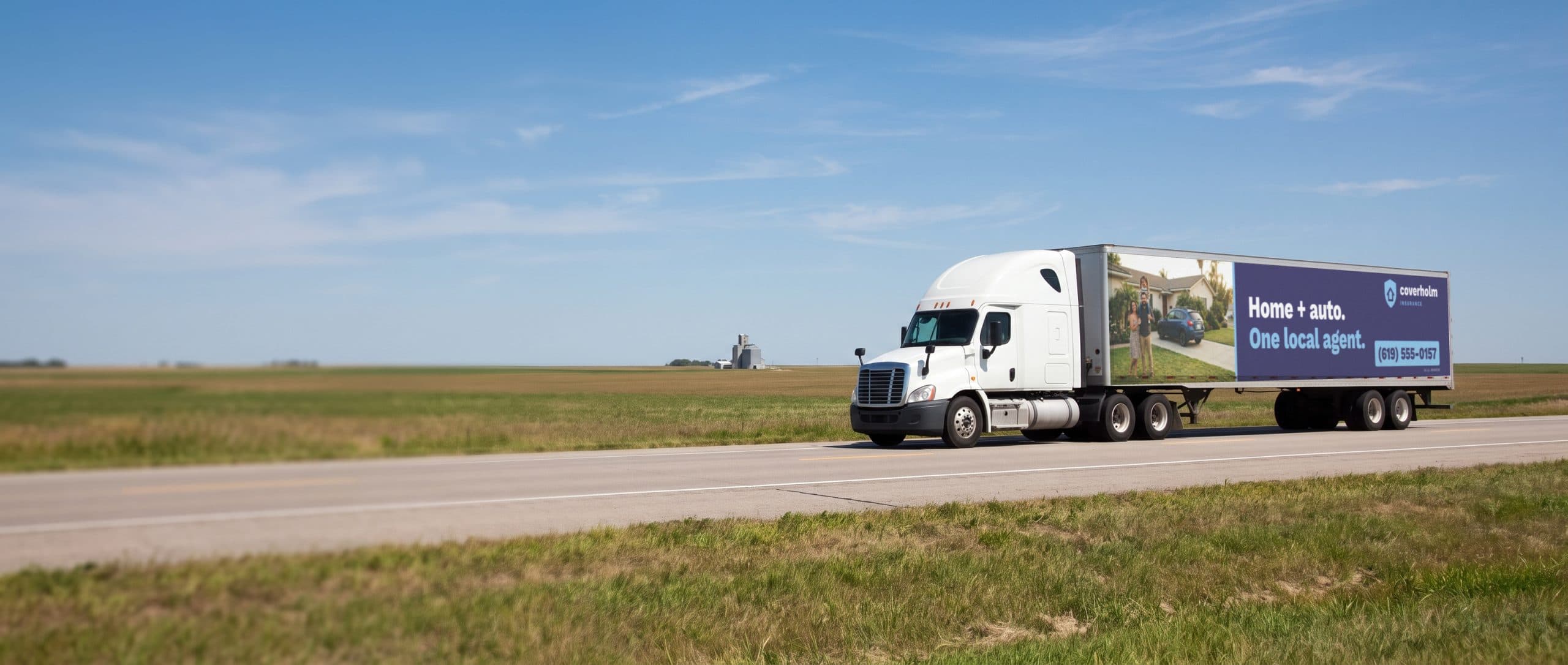 A semi truck on a Midwest interstate with an insurance agency ad along its trailer.