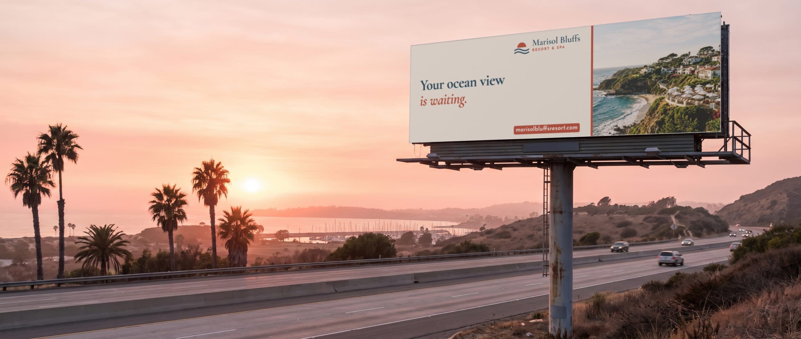 A freeway billboard at sunset on the San Diego coast, showing a coastal resort ad.