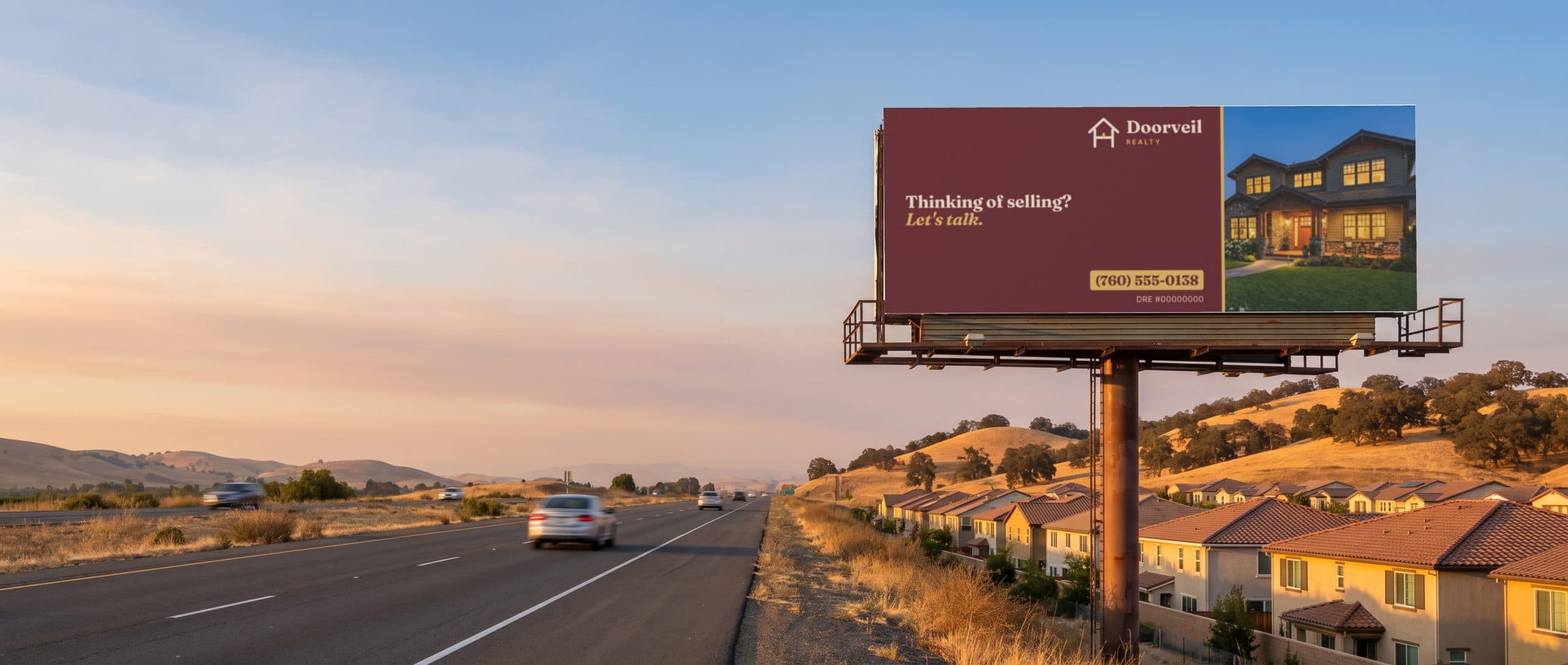 A billboard beside a California suburb at golden hour, showing a real estate agency ad.