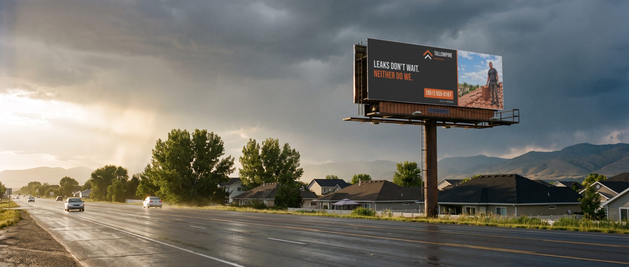 A billboard under a storm sky above Colorado suburban rooftops, showing a roofing company ad.