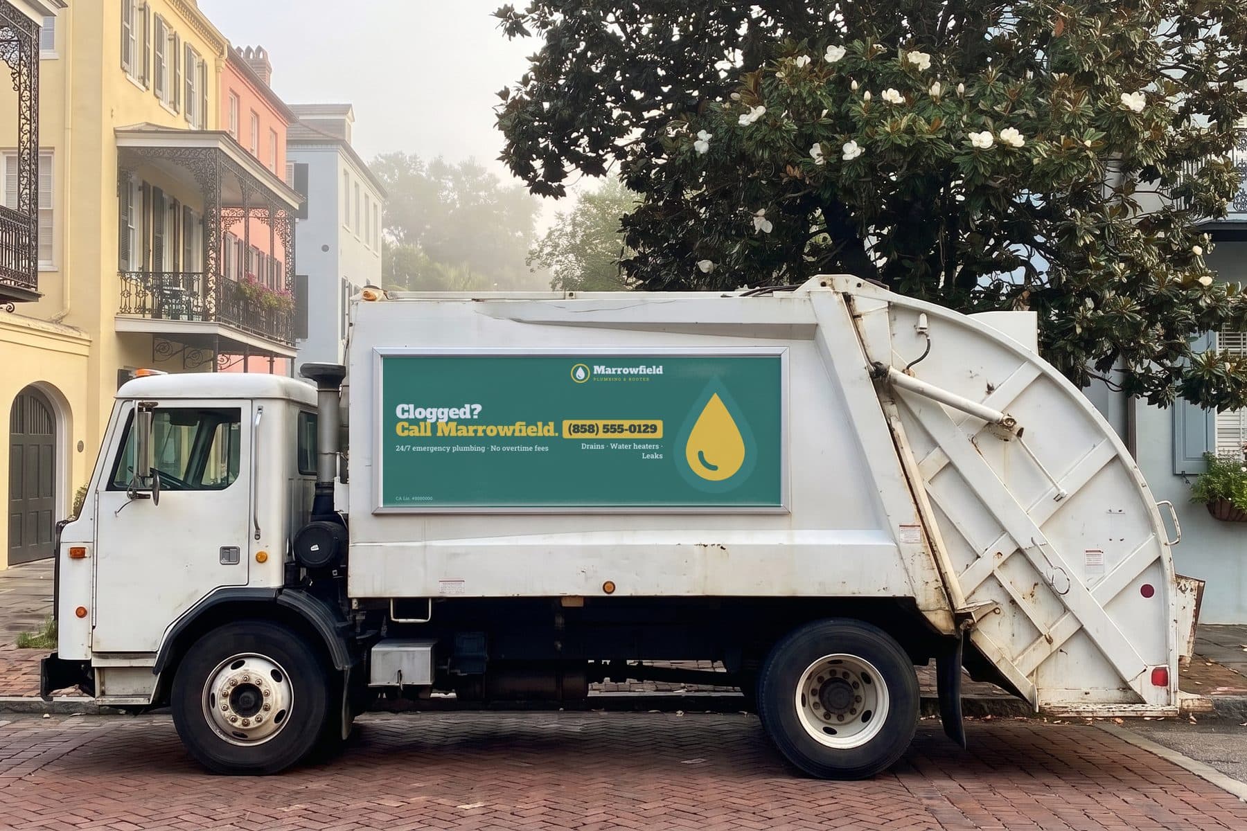 The same truck with a printed panel ad for a fictional plumbing company in the frame